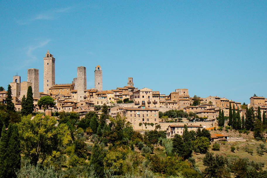 Blick auf die Skyline von San Gimignano: Türme und Gebäude hinter Bäumen